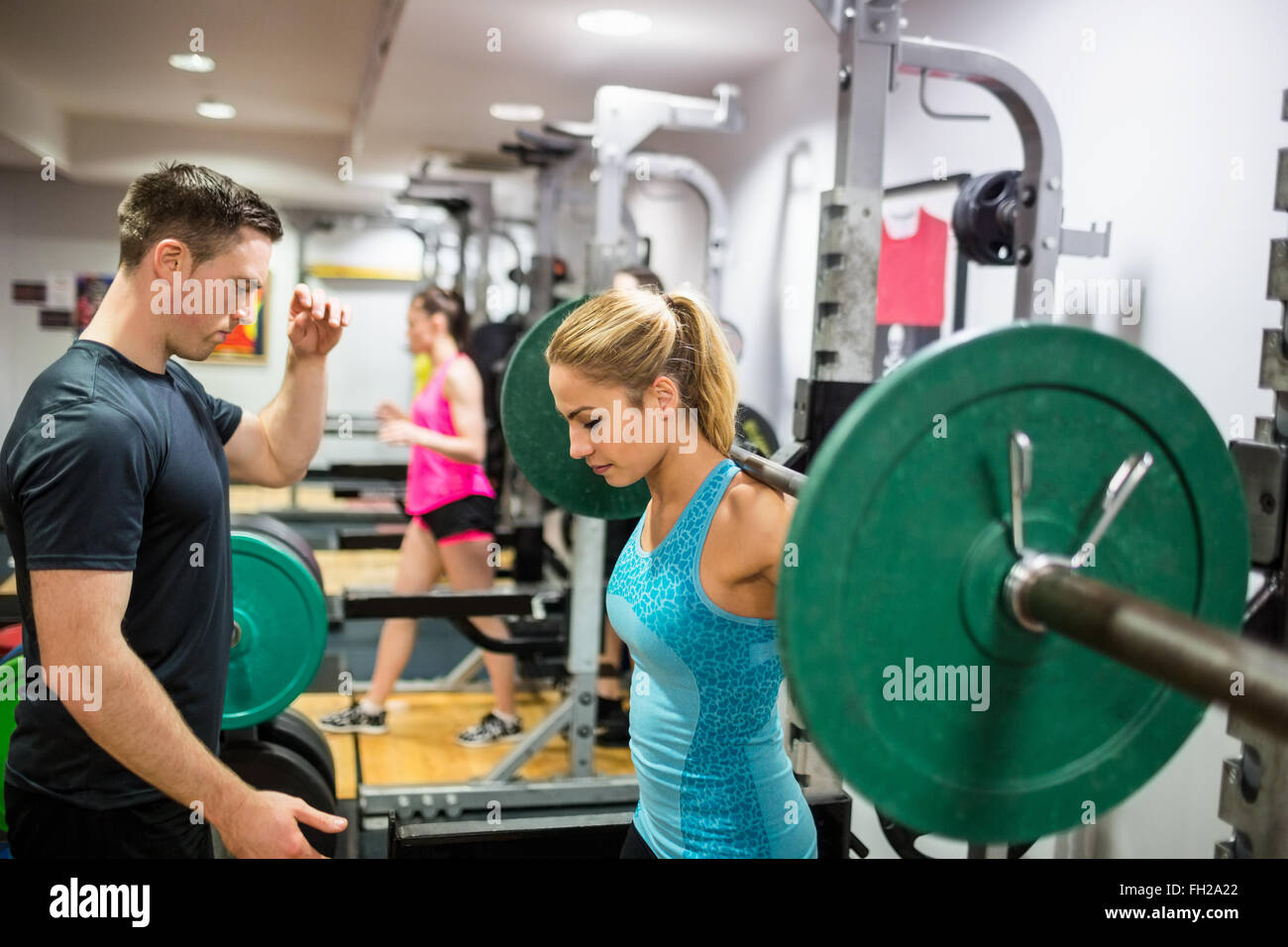 Fit woman lifting heavy barbell in weights room Stock Photo Alamy