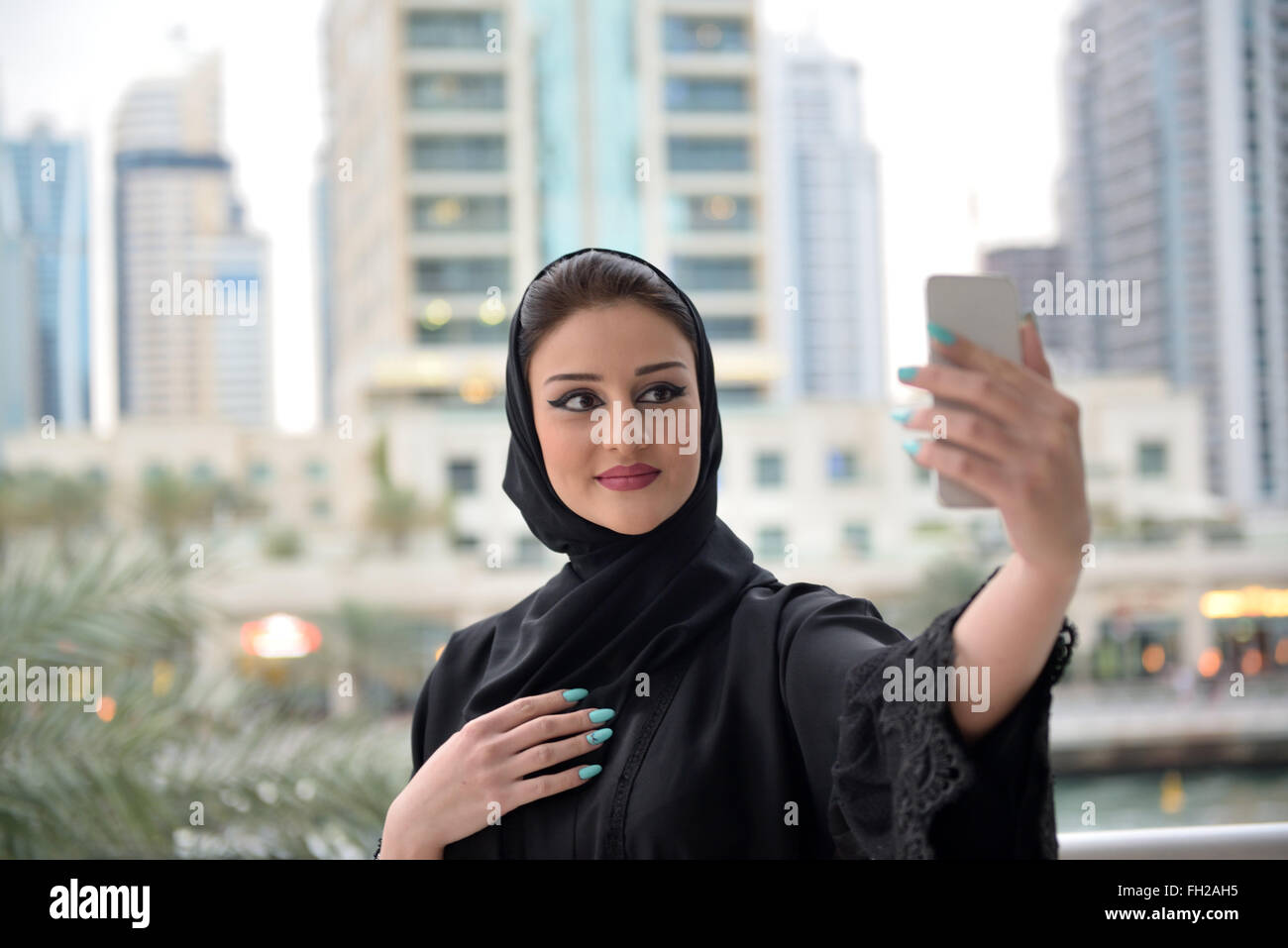 Young beautiful Emirati arab woman taking selfie with her smartphone Stock Photo