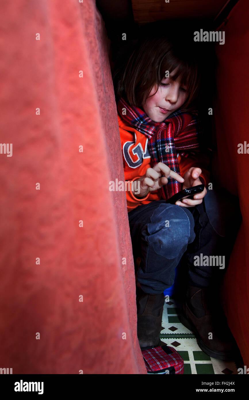 7 year old boy playing with a mobile phone. Stock Photo