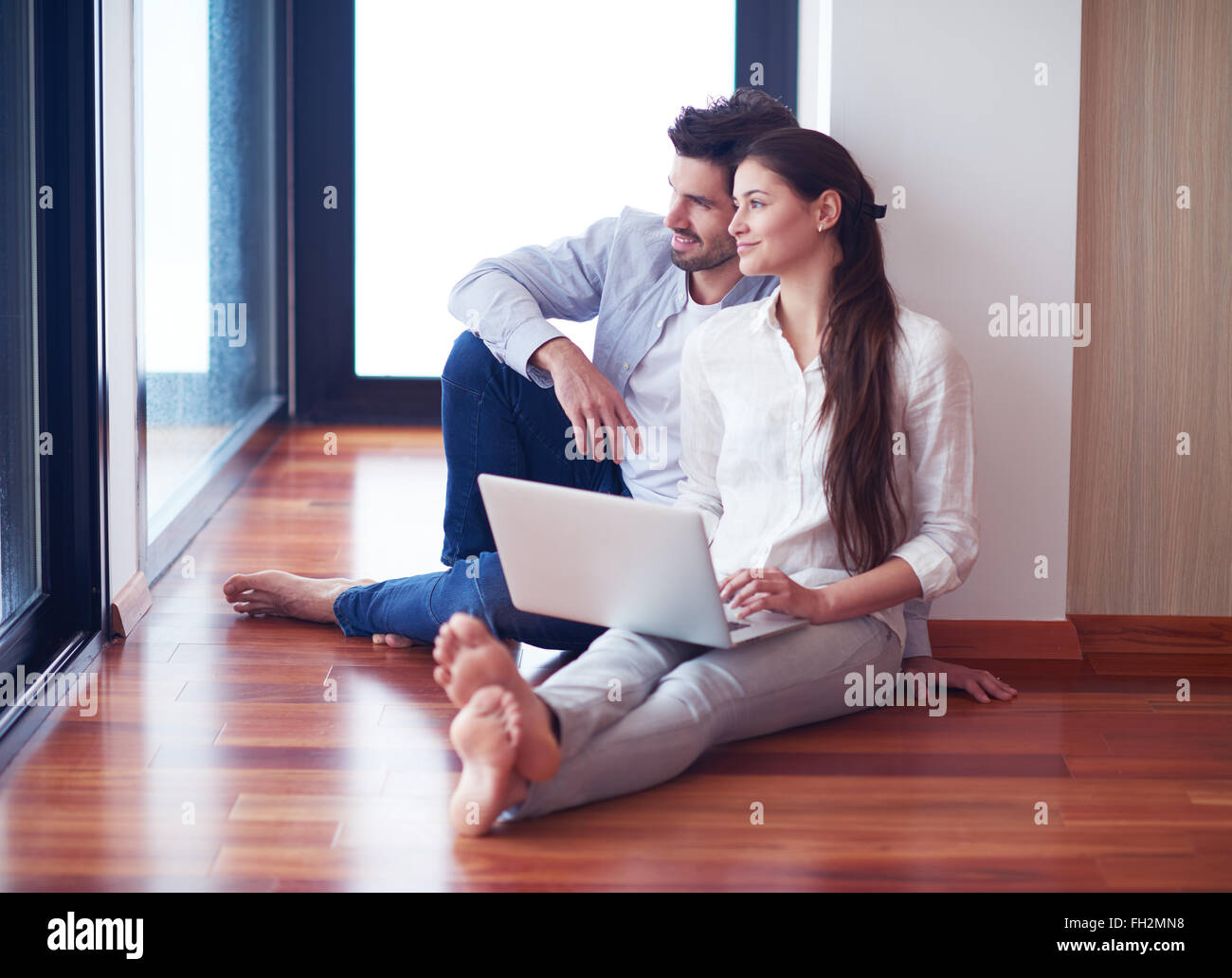 relaxed young couple working on laptop computer at home Stock Photo - Alamy
