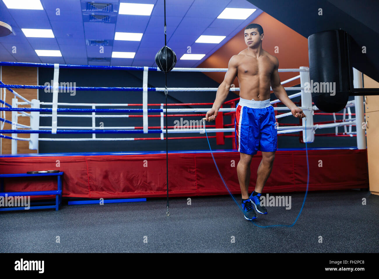 Full length portrait of a boxer jumping with skipping rope Stock Photo
