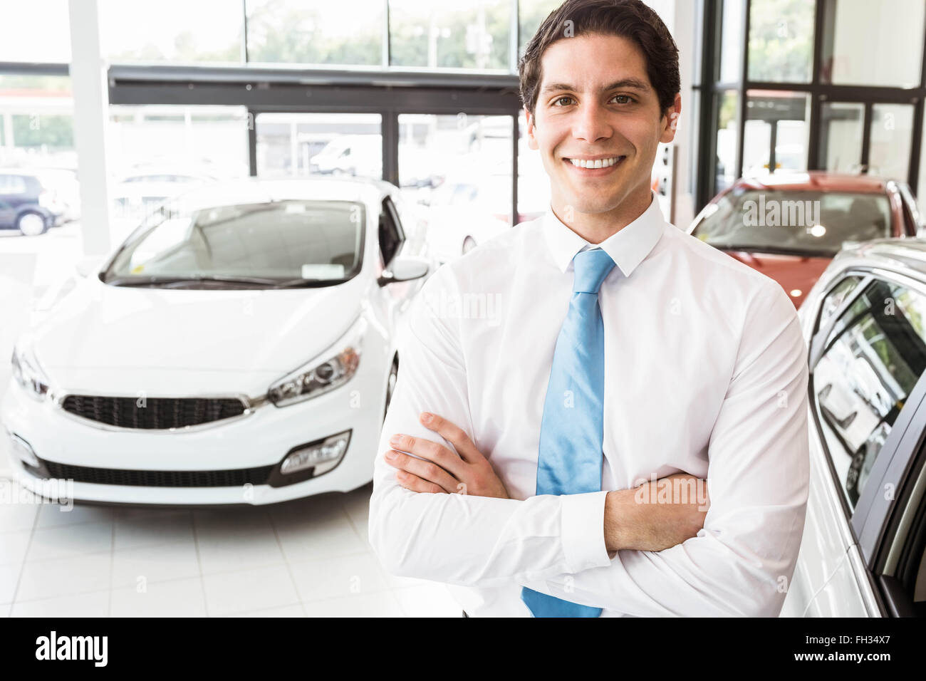 Smiling businessman standing with arms crossed Stock Photo - Alamy