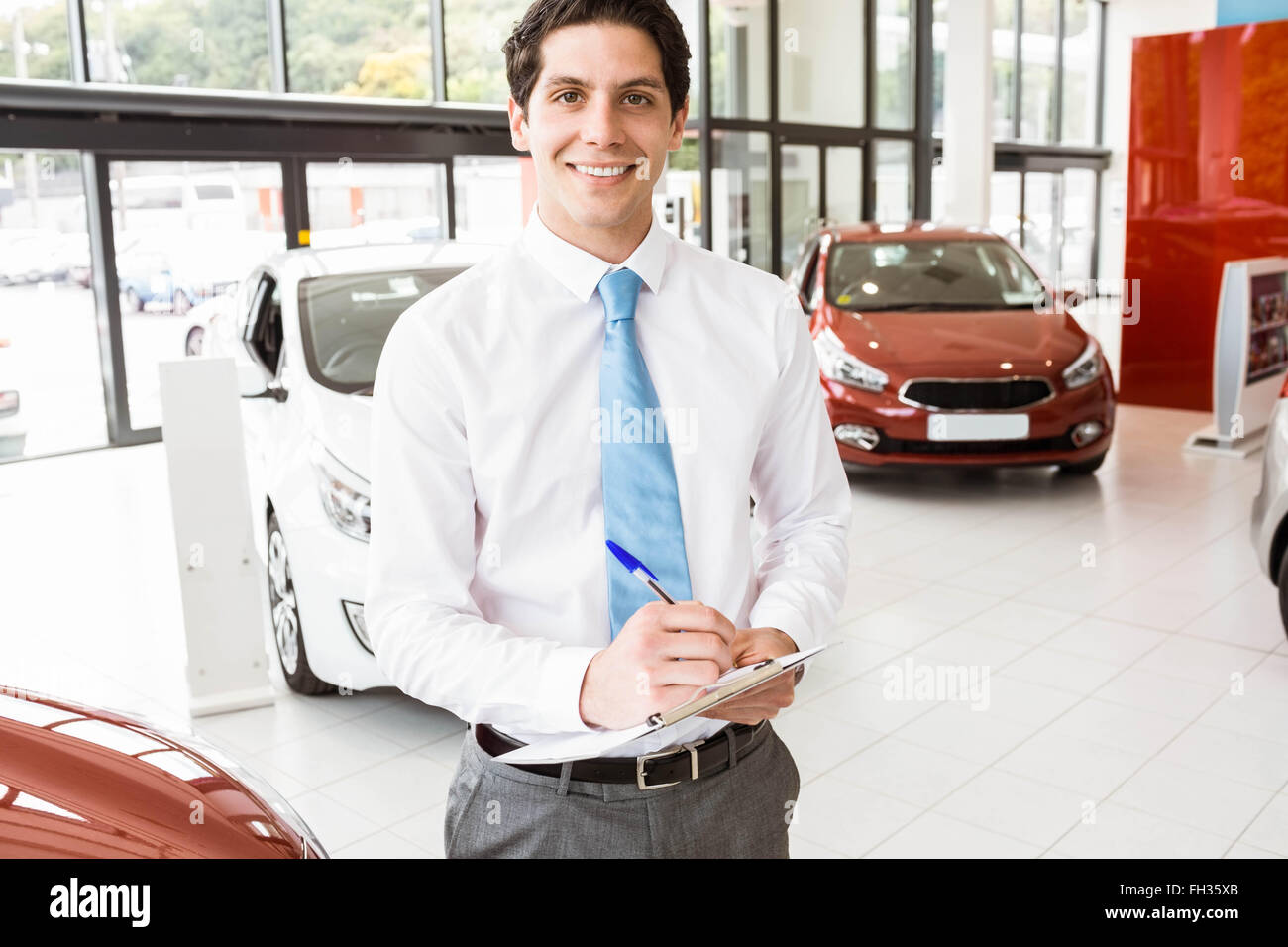 Smiling businessman writing on clipboard Stock Photo - Alamy