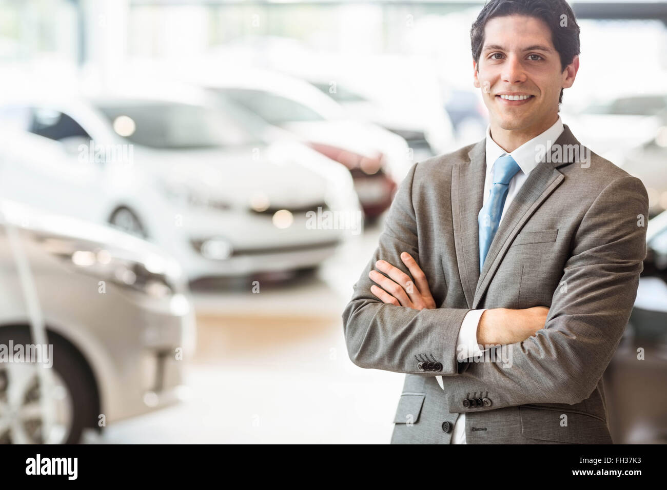 Smiling businessman standing with arms crossed Stock Photo - Alamy