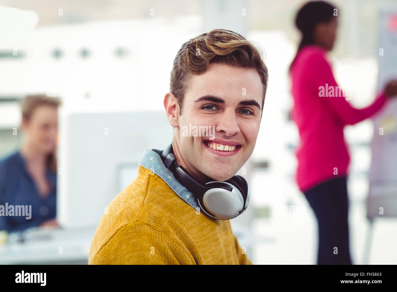 Graphic designer wearing headphones at desk Stock Photo Alamy