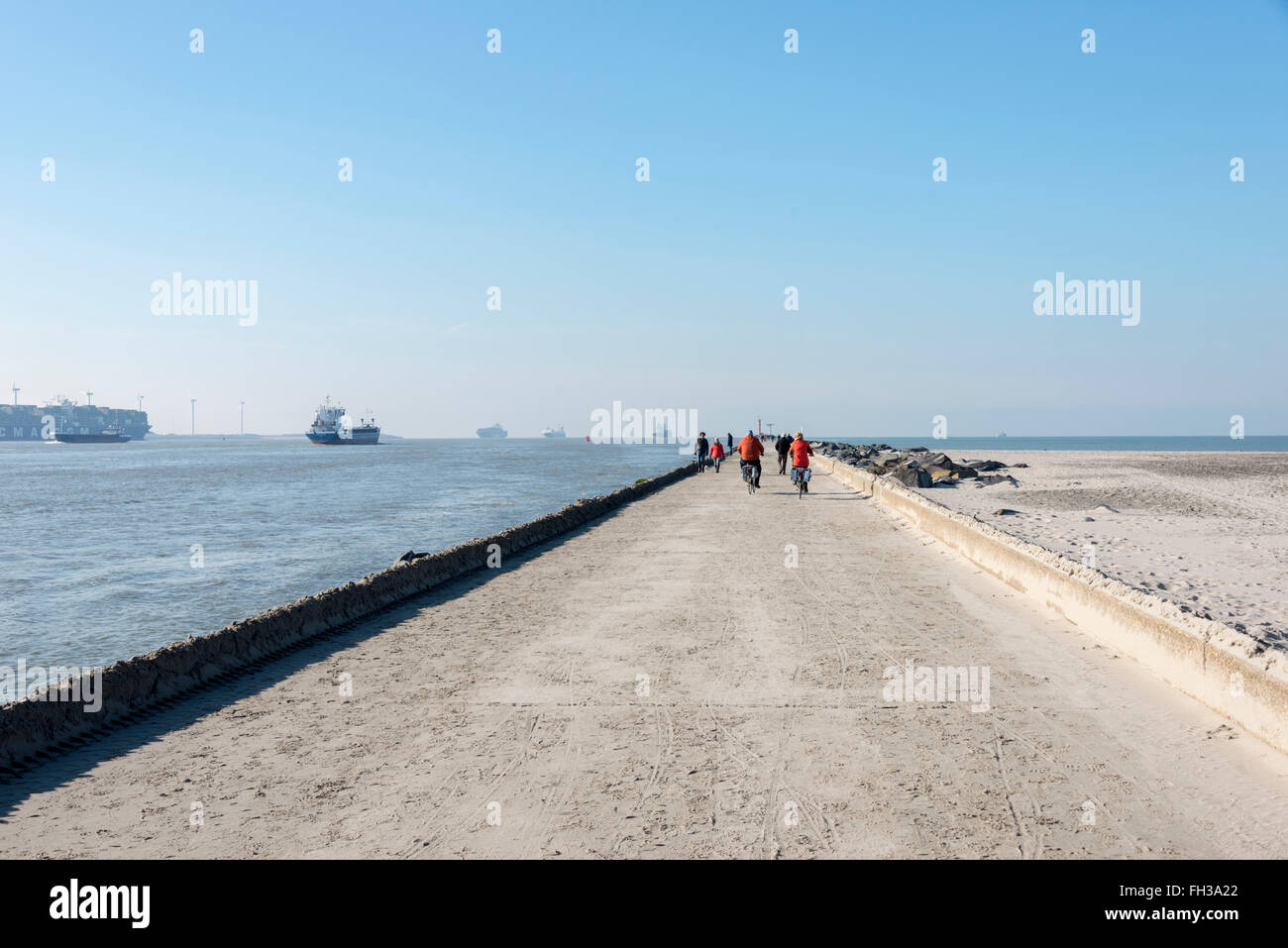 HOEK VAN HOLLAND,NETHERLANDS - FEBRUARI 17: Unidentified people biking on the pier of hoek van holland near the sea on Februari Stock Photo