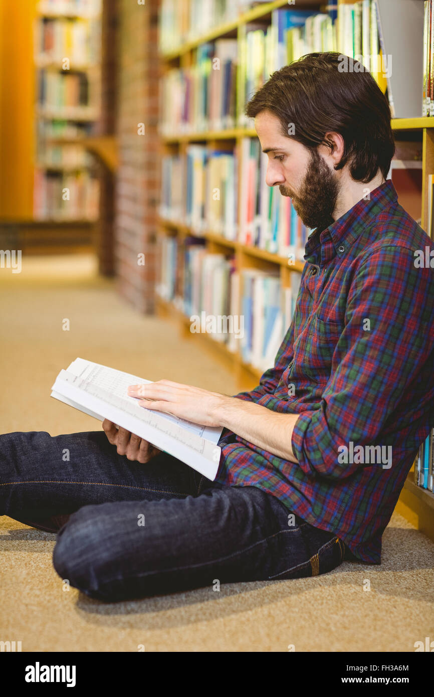 Student reading book in library on floor Stock Photo - Alamy