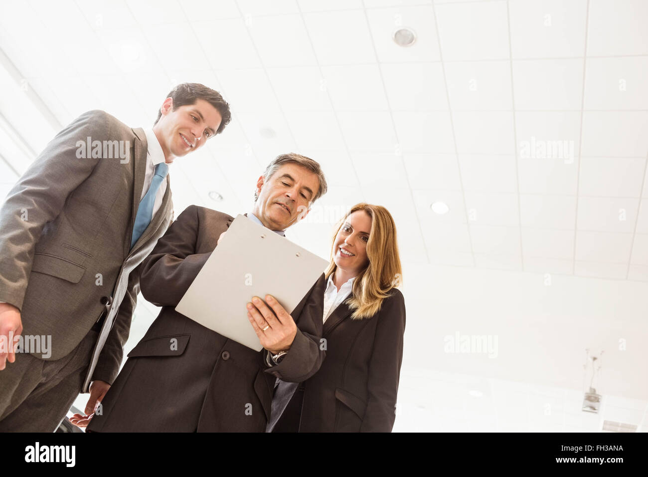 Group of smiling business team standing together Stock Photo - Alamy