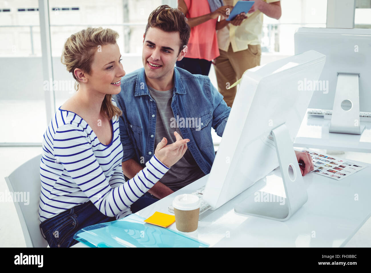 Creative business team working hard together on pc Stock Photo - Alamy