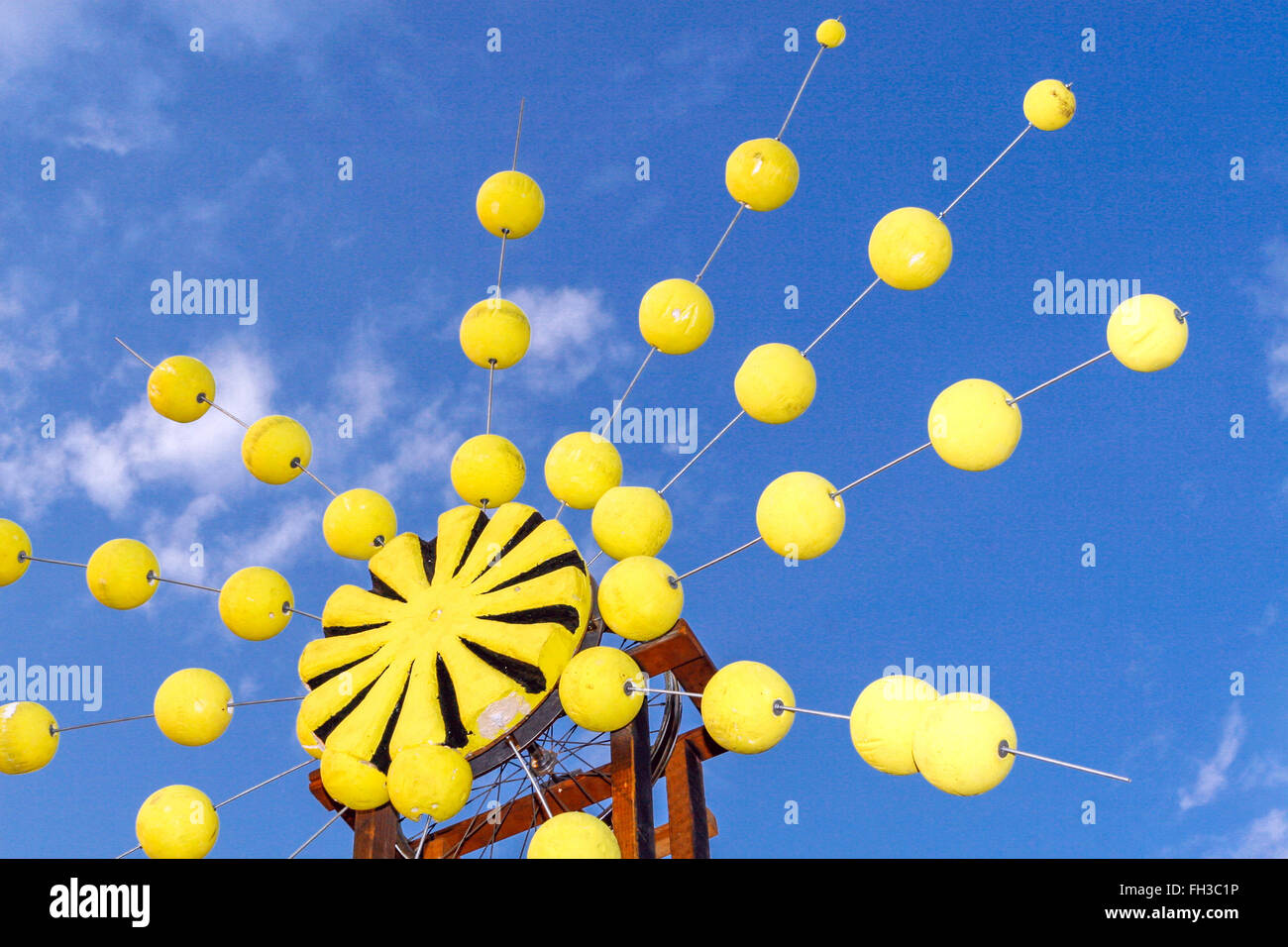 Yellow object with a balls under a blue sky looking up to sky Stock Photo