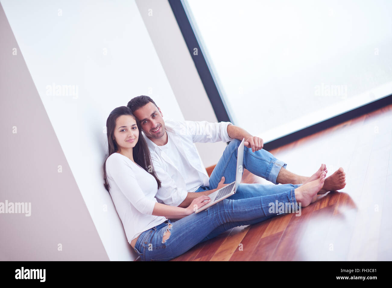 relaxed young couple working on laptop computer at home Stock Photo - Alamy
