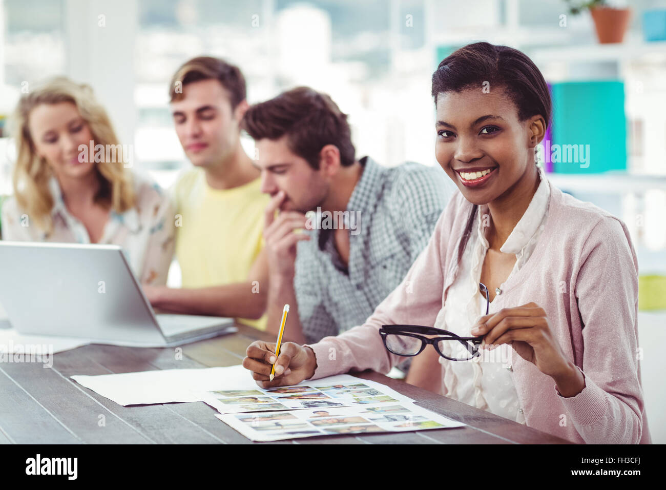 Creative business team working on a laptop together Stock Photo - Alamy