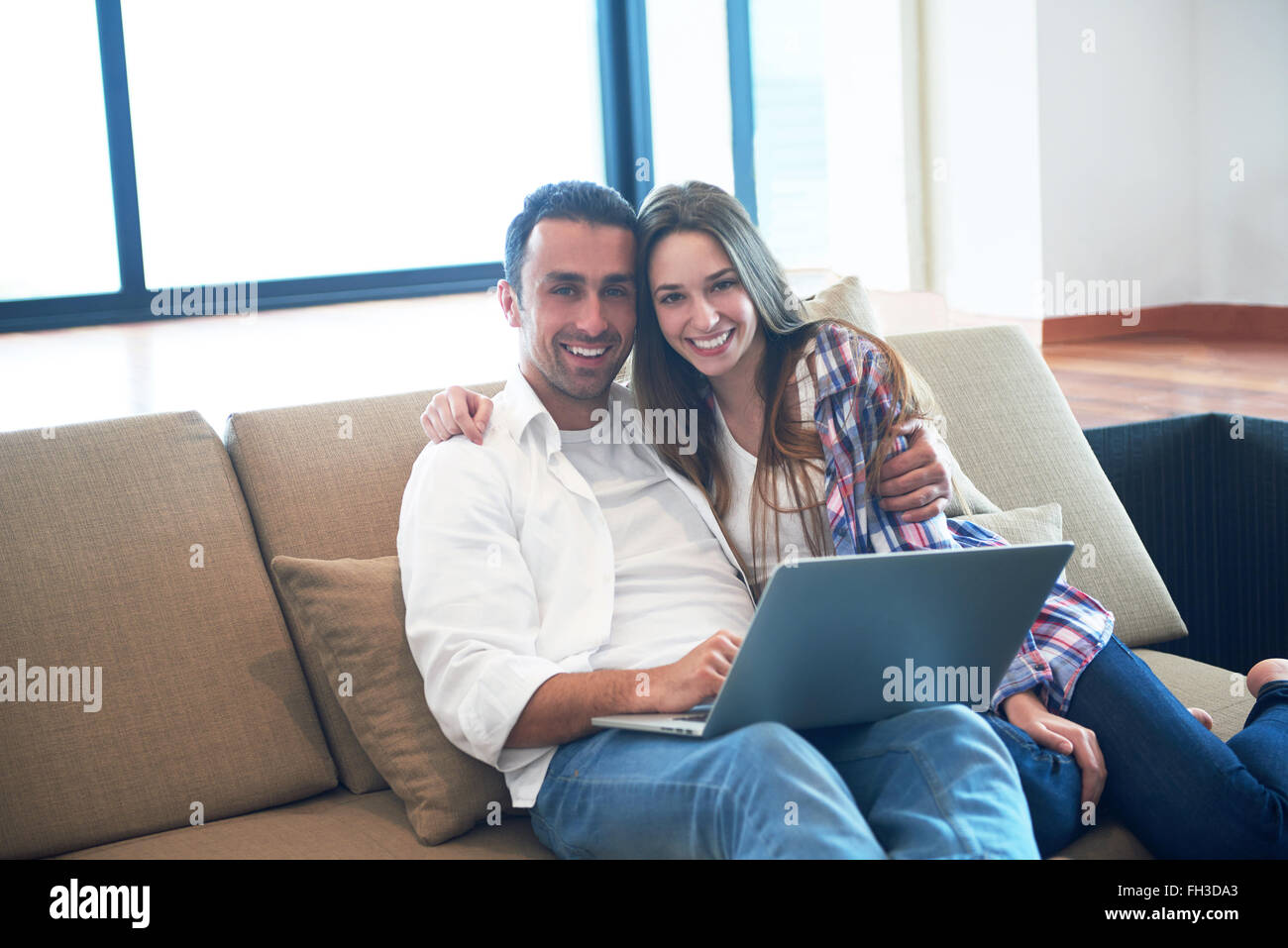relaxed young couple working on laptop computer at home Stock Photo - Alamy