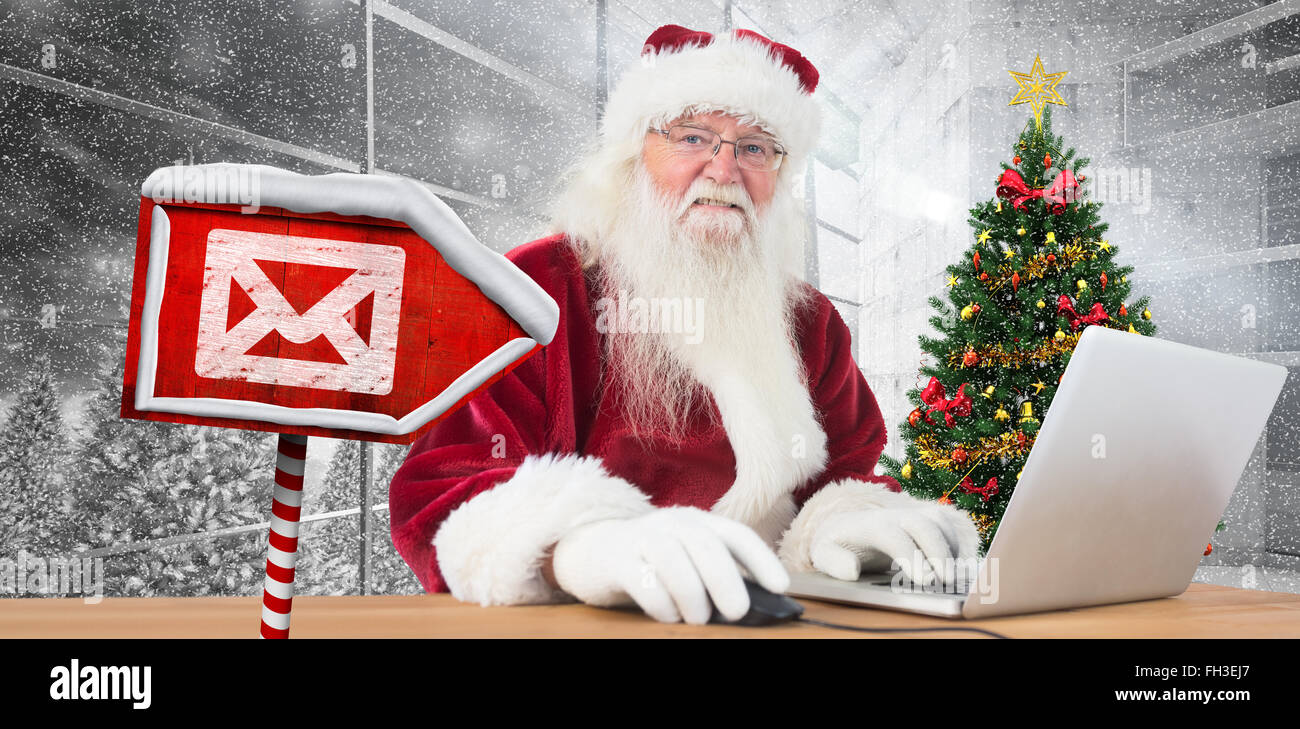 Composite image of santa surfs on the internet Stock Photo