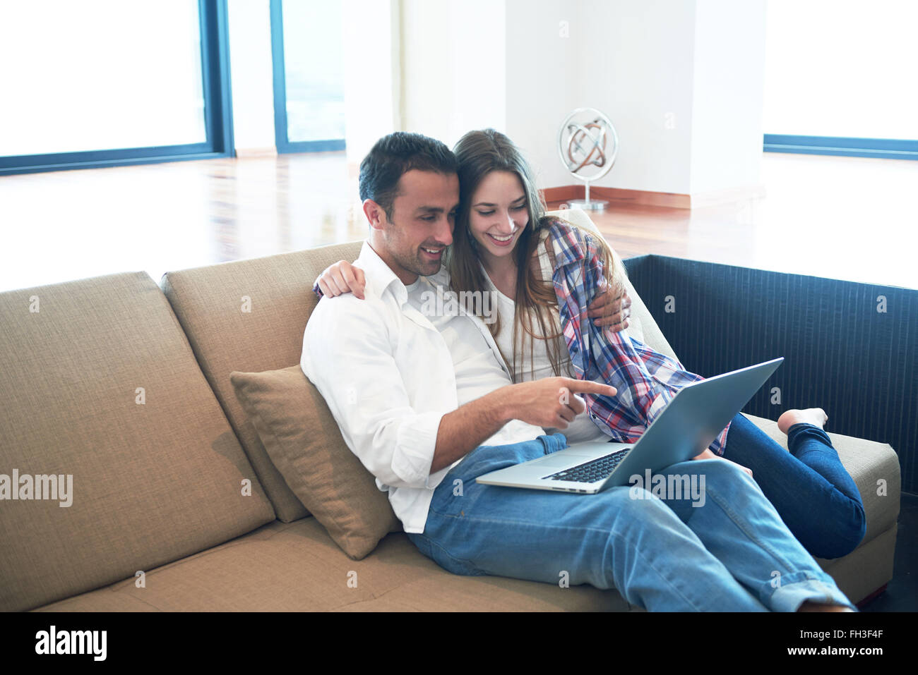 relaxed young couple working on laptop computer at home Stock Photo - Alamy