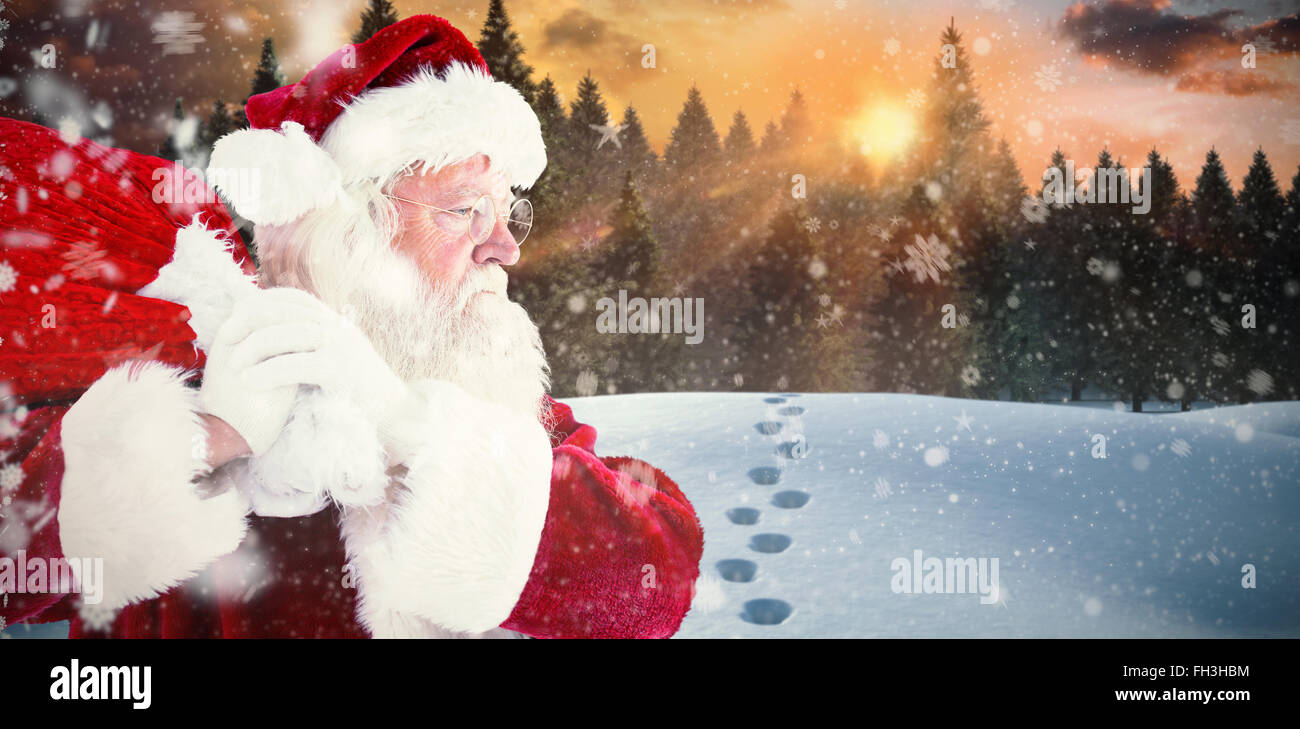 Composite image of santa claus carrying sack Stock Photo - Alamy