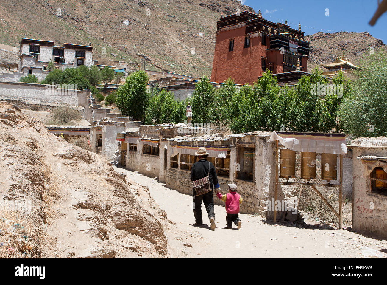 Father and son walking along the Kora path behind Tashilhunpo monastery Shigatse Tibet Stock Photo