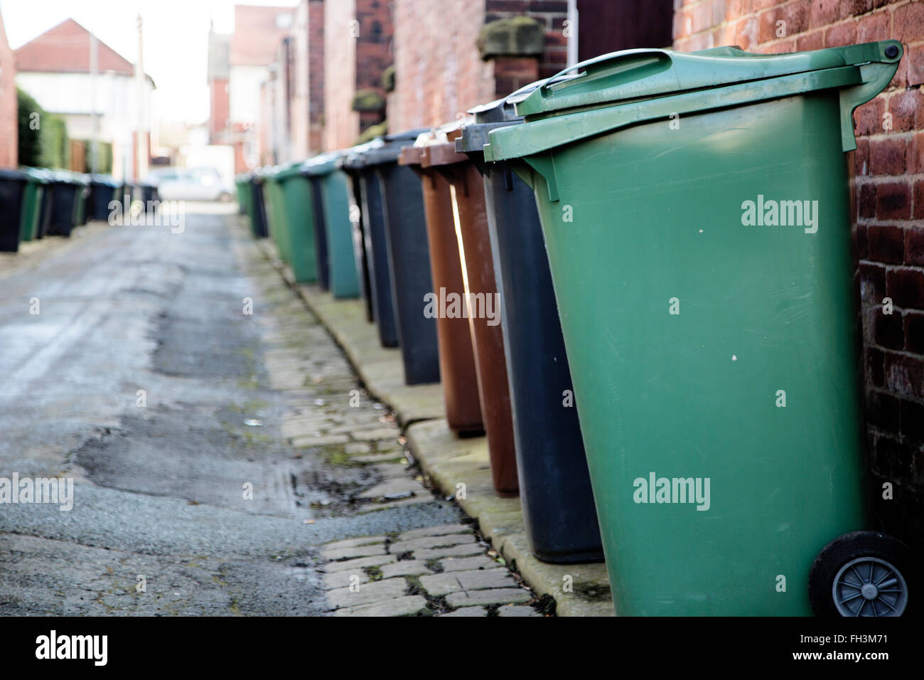 Wheelie bins line both sides of a backstreet in Leeds, West Yorkshire ...