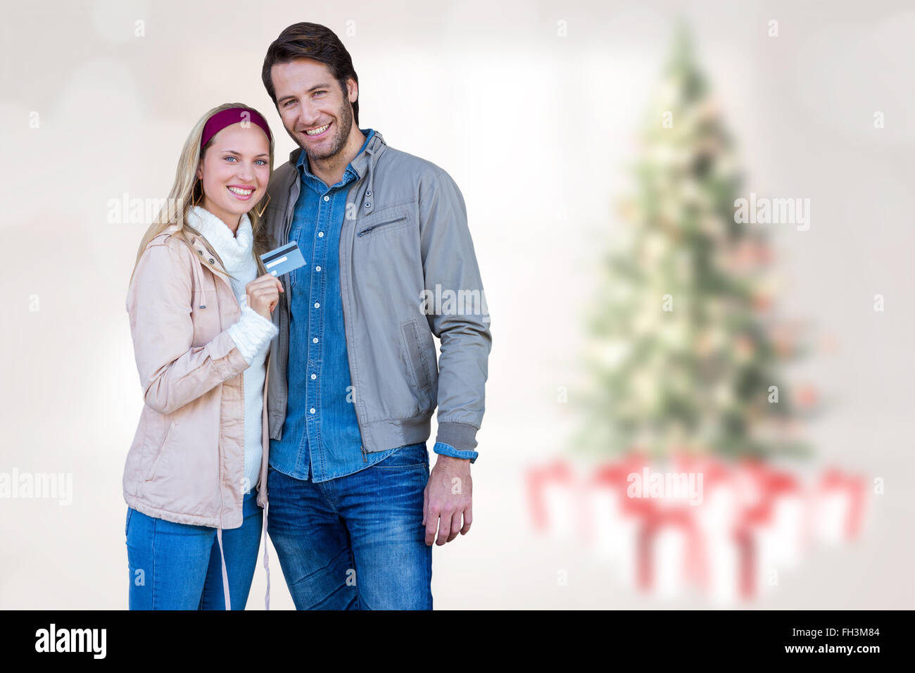Composite image of smiling couple showing credit card Stock Photo - Alamy