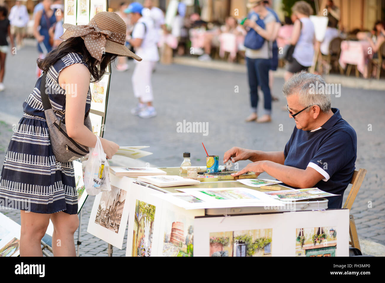 Rome, Italy - August 22, 2015: the famous Navona square a man selling pictures to a tourist girl Stock Photo