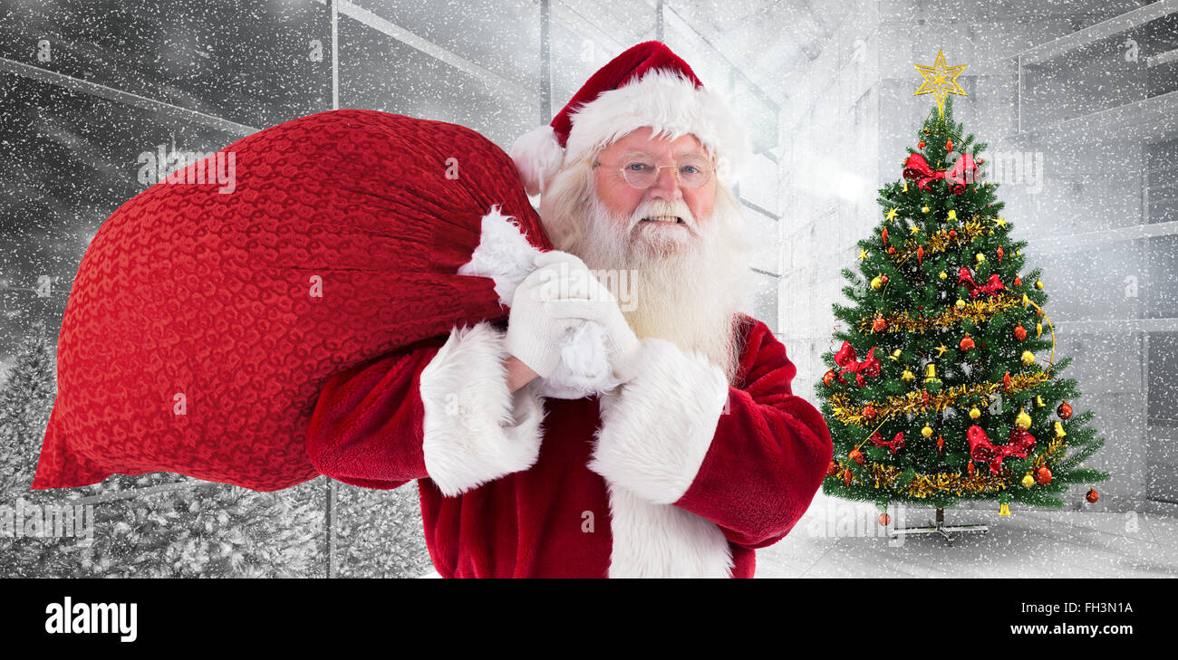 Composite image of santa carries his red bag and smiles Stock Photo - Alamy