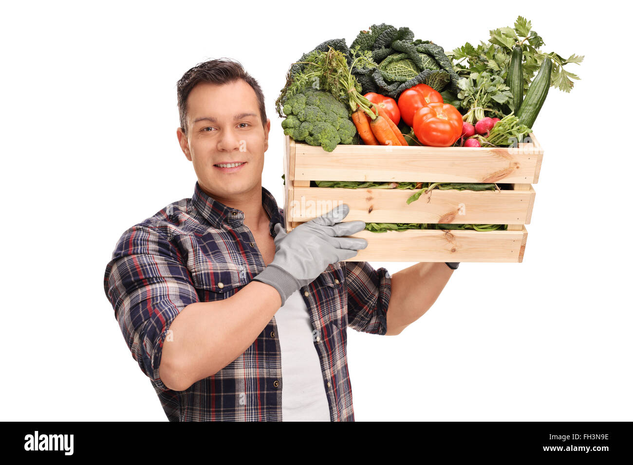 Young male farmer carrying a wooden crate full of fresh vegetables ...