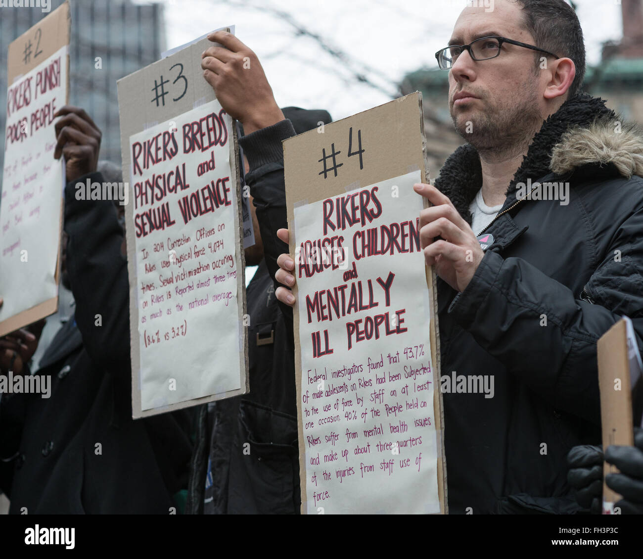 New York, United States. 23rd Feb, 2016. Demonstrators hold aloft signs inscribed with the reasons that they deman Rikers Island be closed. A confederacy of about a dozen prison reform activists rallied at City Hall in New York City to demand that it close the long-controversial Rikers Island Corrections facility where, among others, Kalief Browder, died; critics maintain that the prison is unsafe and prolonged detention of inmates at the facility is a violation of Constitutional due process rights. Credit:  Albin Lohr-Jones/Pacific Press/Alamy Live News Stock Photo