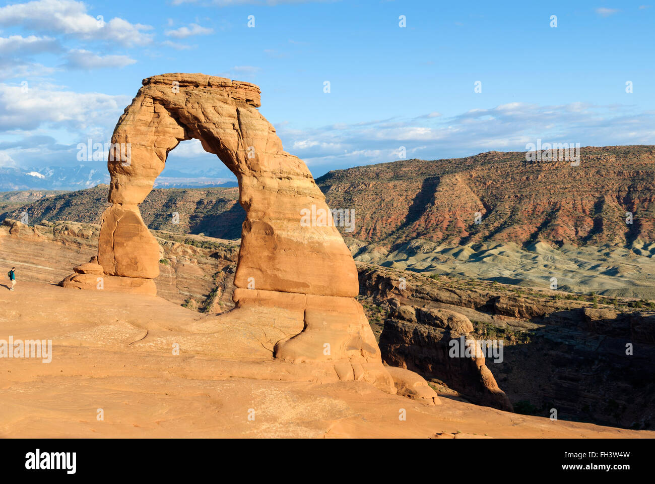 A tourist walks towards Delicate Arch in Arches national Park, Utah, USA Stock Photo