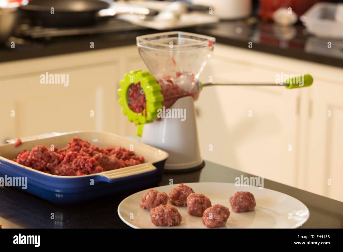 Raw meat being minced in a family kitchen and then turned into meatballs Stock Photo