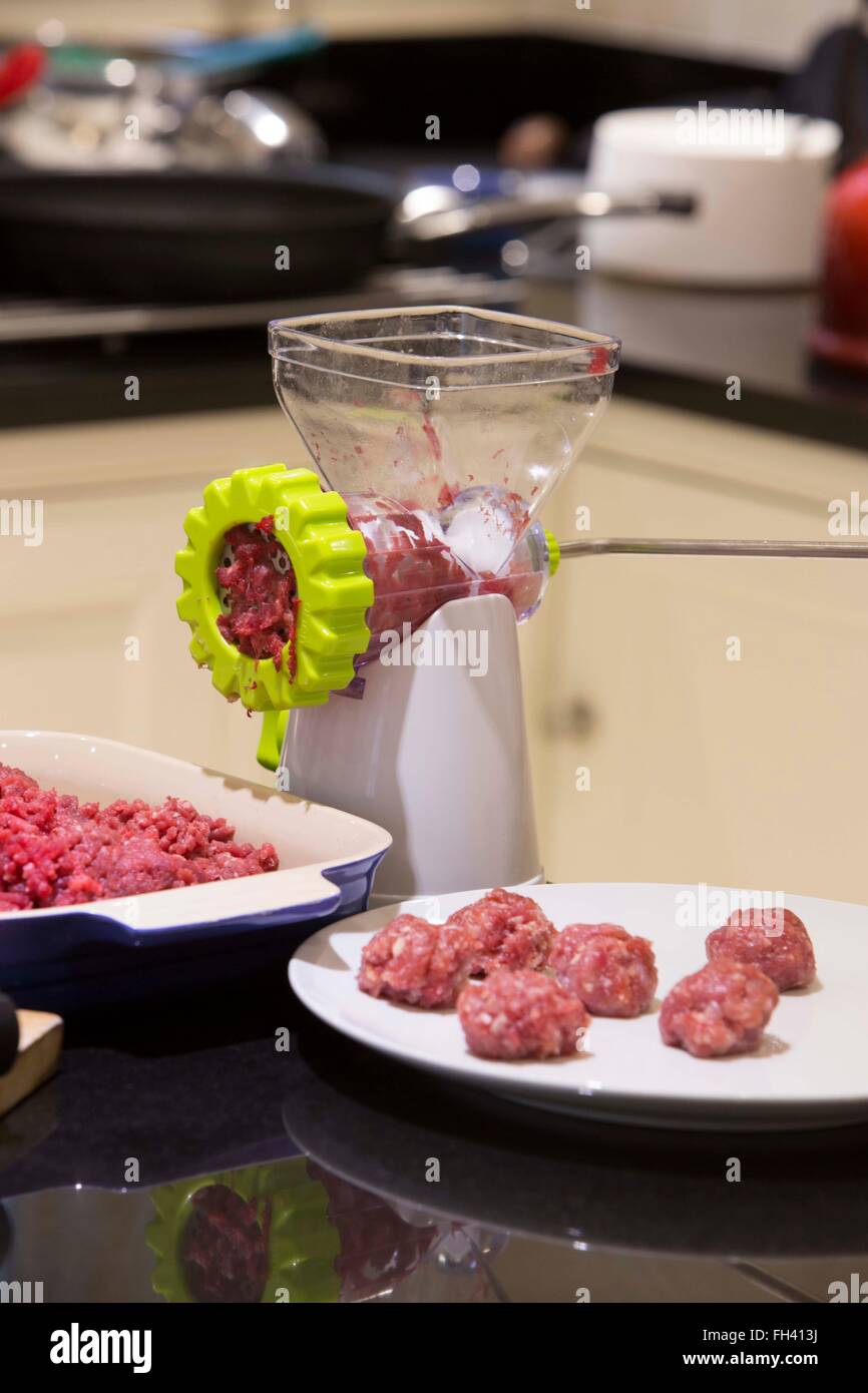 Using a domestic mincer to mince beef then make meatballs in a family