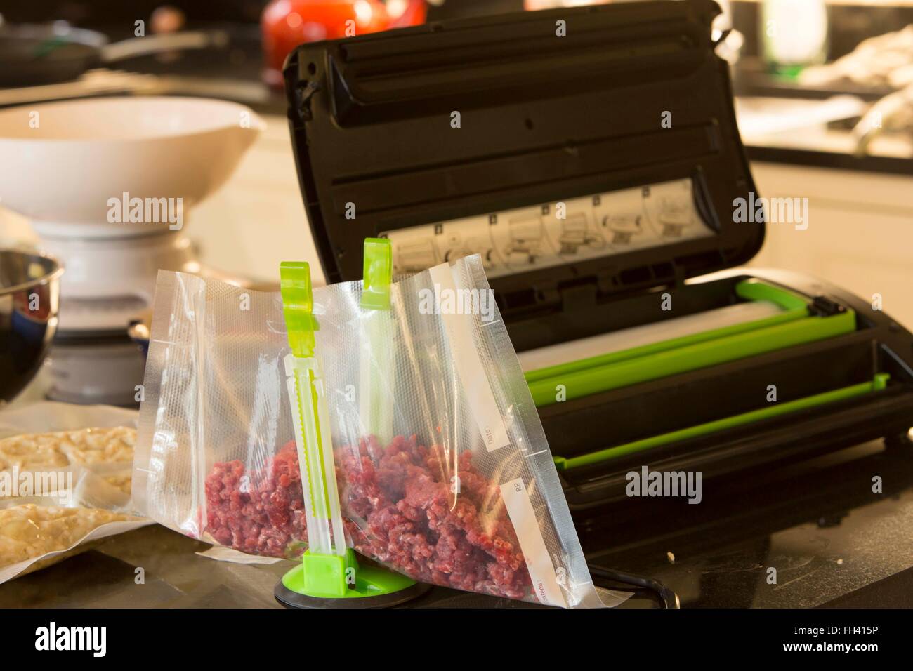 Preparing food for the freezer at home using a vacuum sealer to keep the meat (beef in this case) fresh. Stock Photo