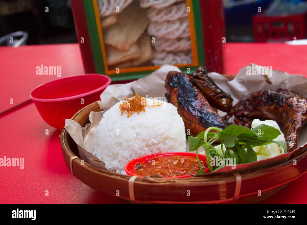Street food along the streets of Jakarta, rice, grilled chicken and vegetables Stock Photo