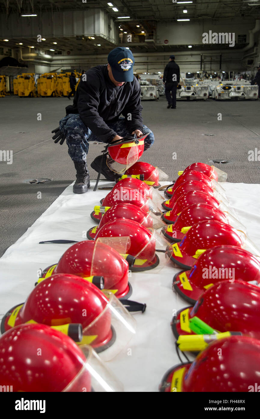 NORFOLK, Va. (Feb. 22, 2016) - Airman Derron Darty inspects firefighting helmets in the hangar bay of the aircraft carrier USS Dwight D. Eisenhower (CVN 69). Dwight D. Eisenhower is currently undergoing the Board of Inspection and Survey (INSURV). Stock Photo