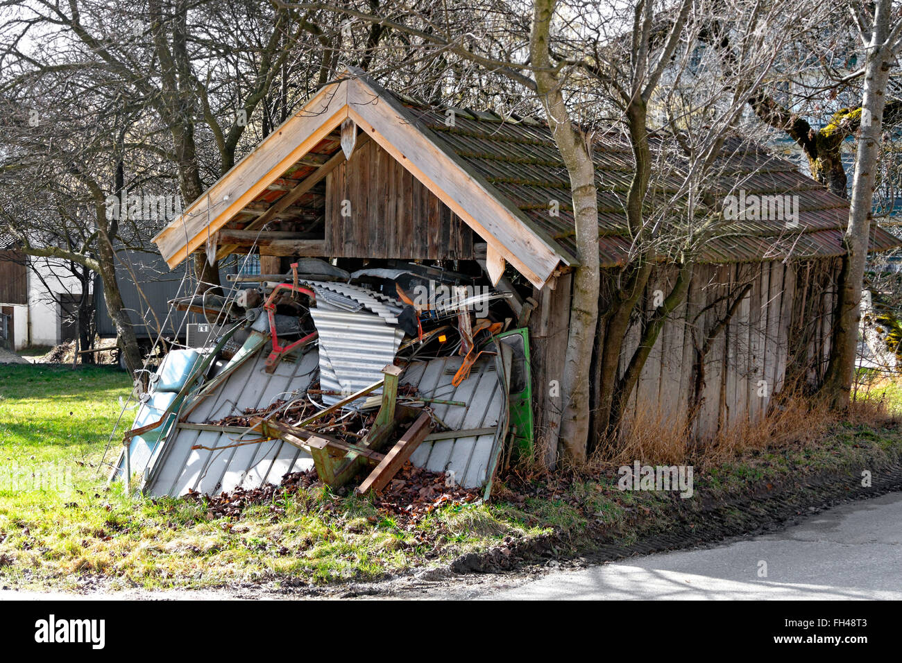 Old wooden shed overflowing with scrap metal, Chiemgau, Upper Bavaria, Germany, Europe Stock Photo