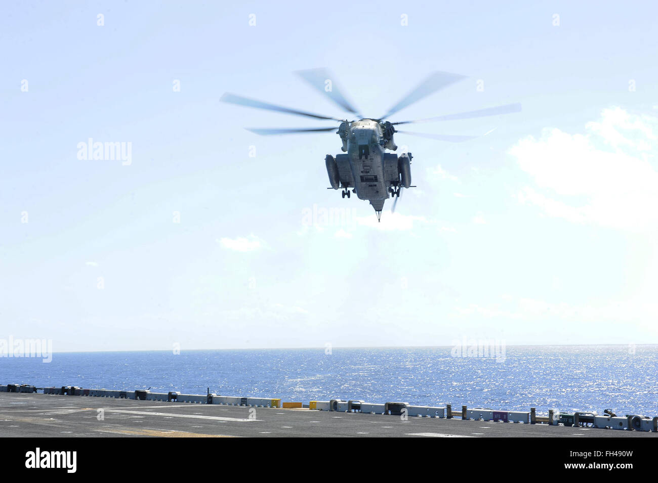 PACIFIC OCEAN (Feb. 22, 2016) A CH-53E Super Stallion, assigned to Marine Medium Tilt Rotor Squadron (VMM) 166 (Reinforced), approaches the flight deck of amphibious assault ship USS Boxer (LHD 4). More than 4,500 Sailors and Marines from Boxer Amphibious Ready Group and the 13th Marine Expeditionary Unit (13th MEU) are conducting sustainment training off the coast of Hawaii in preparation for entering the U.S. 5th and 7th Fleet areas of operations. Stock Photo