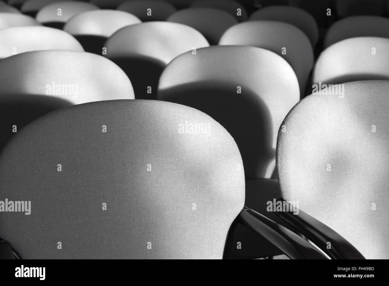 Gray armchairs in a rows, empty auditorium interior fragment Stock Photo