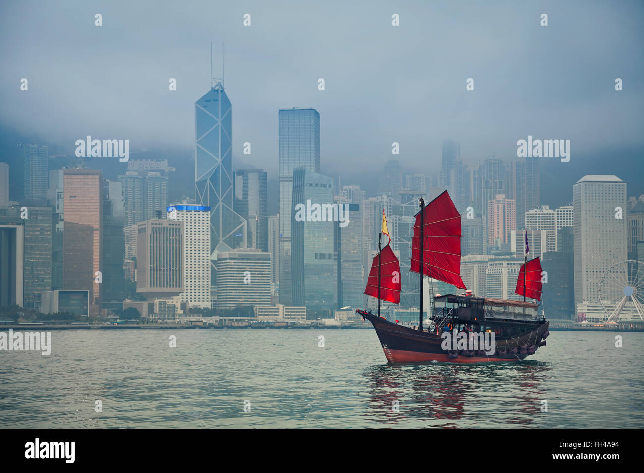Hong Kong, China. Hong Kong Junkboat sailing along Hong Kong Skyline on a foggy day. Stock Photo