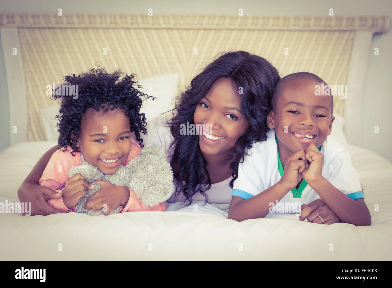 Mother and children lying on bed Stock Photo - Alamy