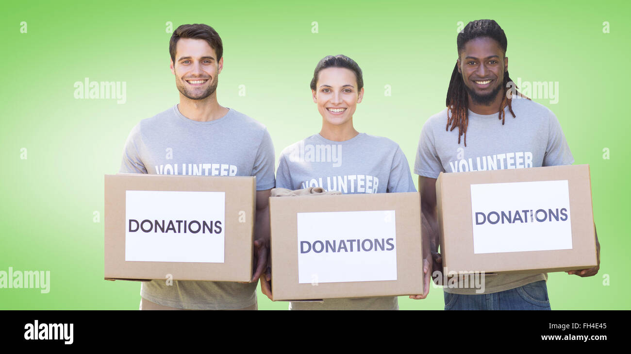 Composite image of happy volunteers with donation boxes in park Stock Photo