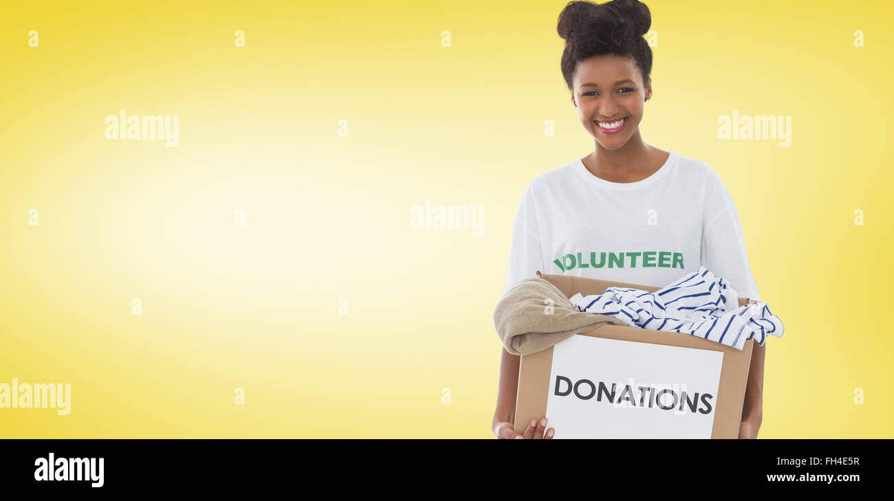 Composite image of smiling young woman with clothes donation Stock Photo