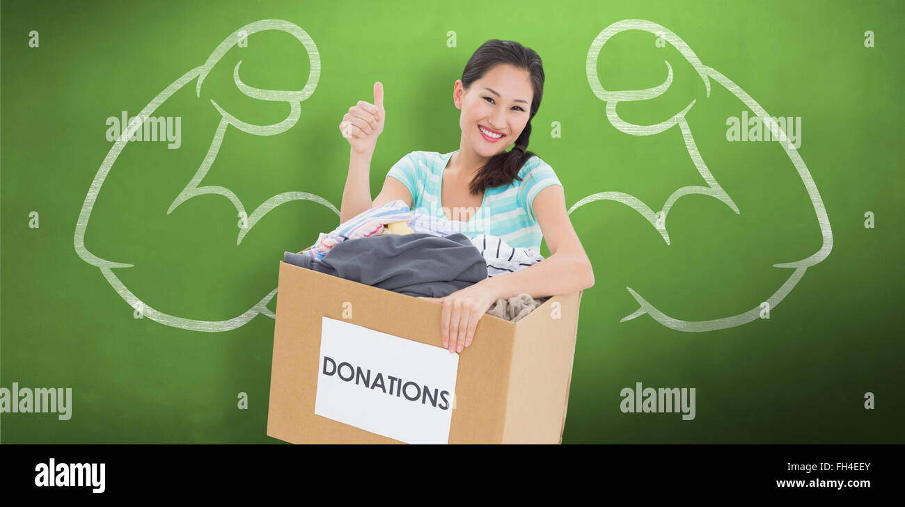 Composite image of woman with clothes donation gesturing thumbs up Stock Photo
