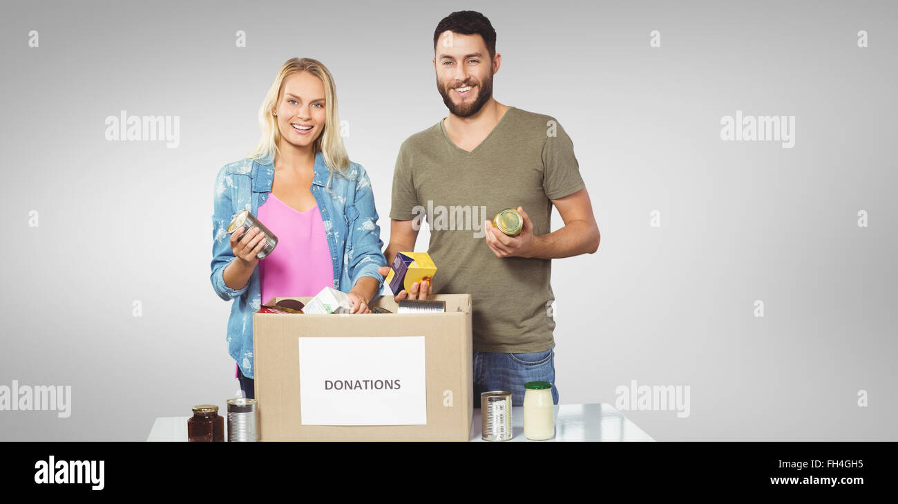Composite image of portrait of happy colleagues smiling while holding products Stock Photo