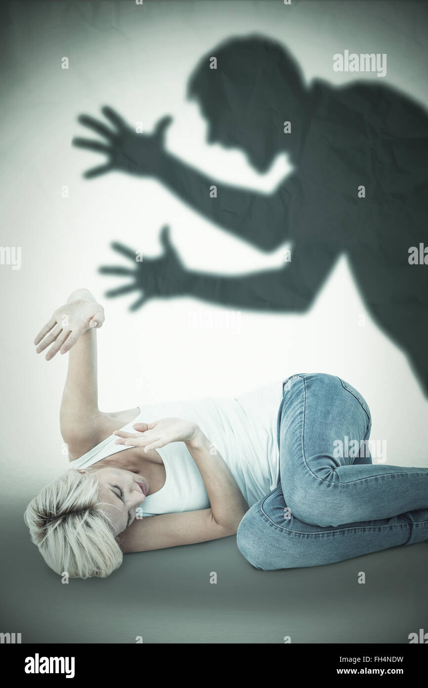 Composite image of scared woman protecting herself Stock Photo