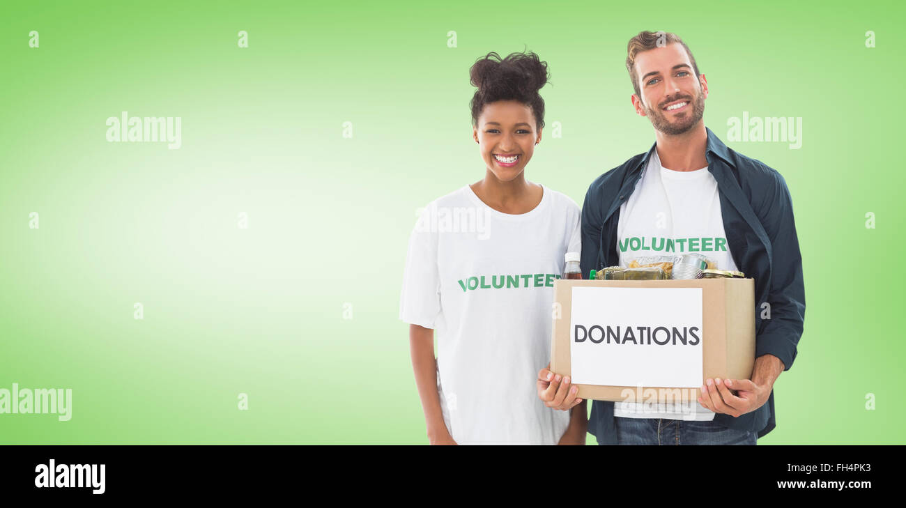 Composite image of smiling young couple with clothes donation Stock Photo