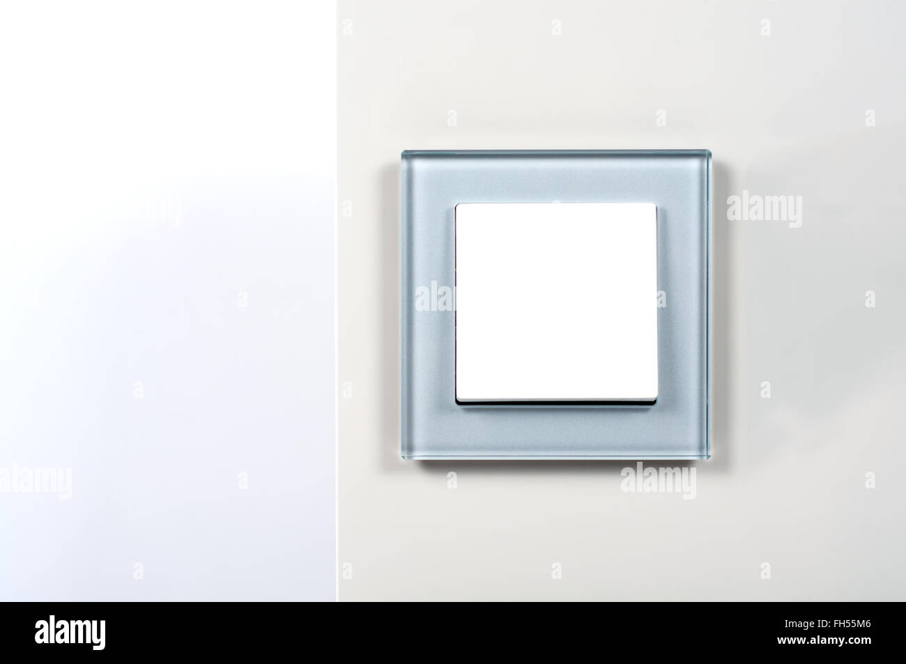 light switch with silver glass frame on the wall Stock Photo
