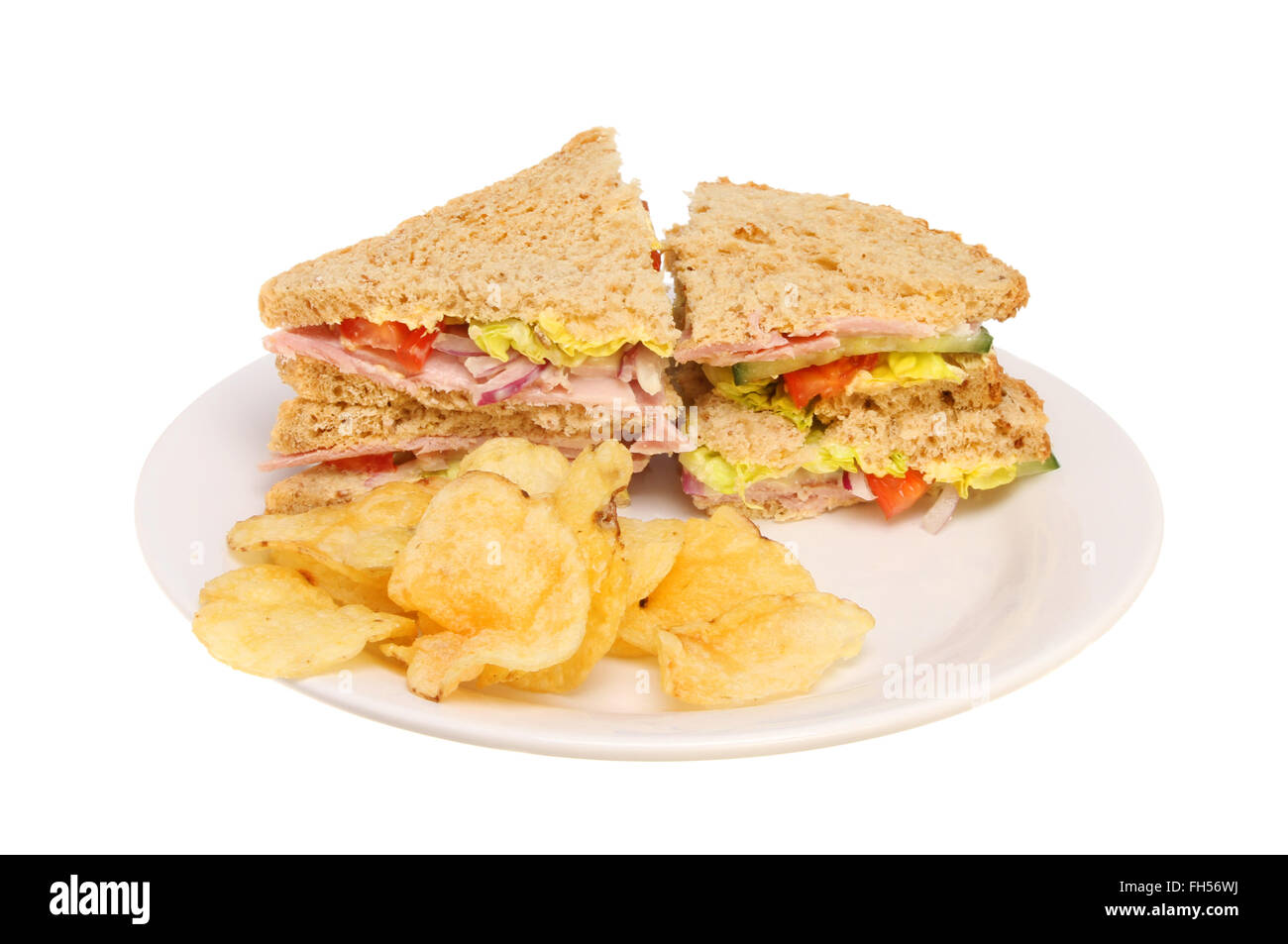 Brown bread ham salad sandwich with potato crisps on a plate isolated