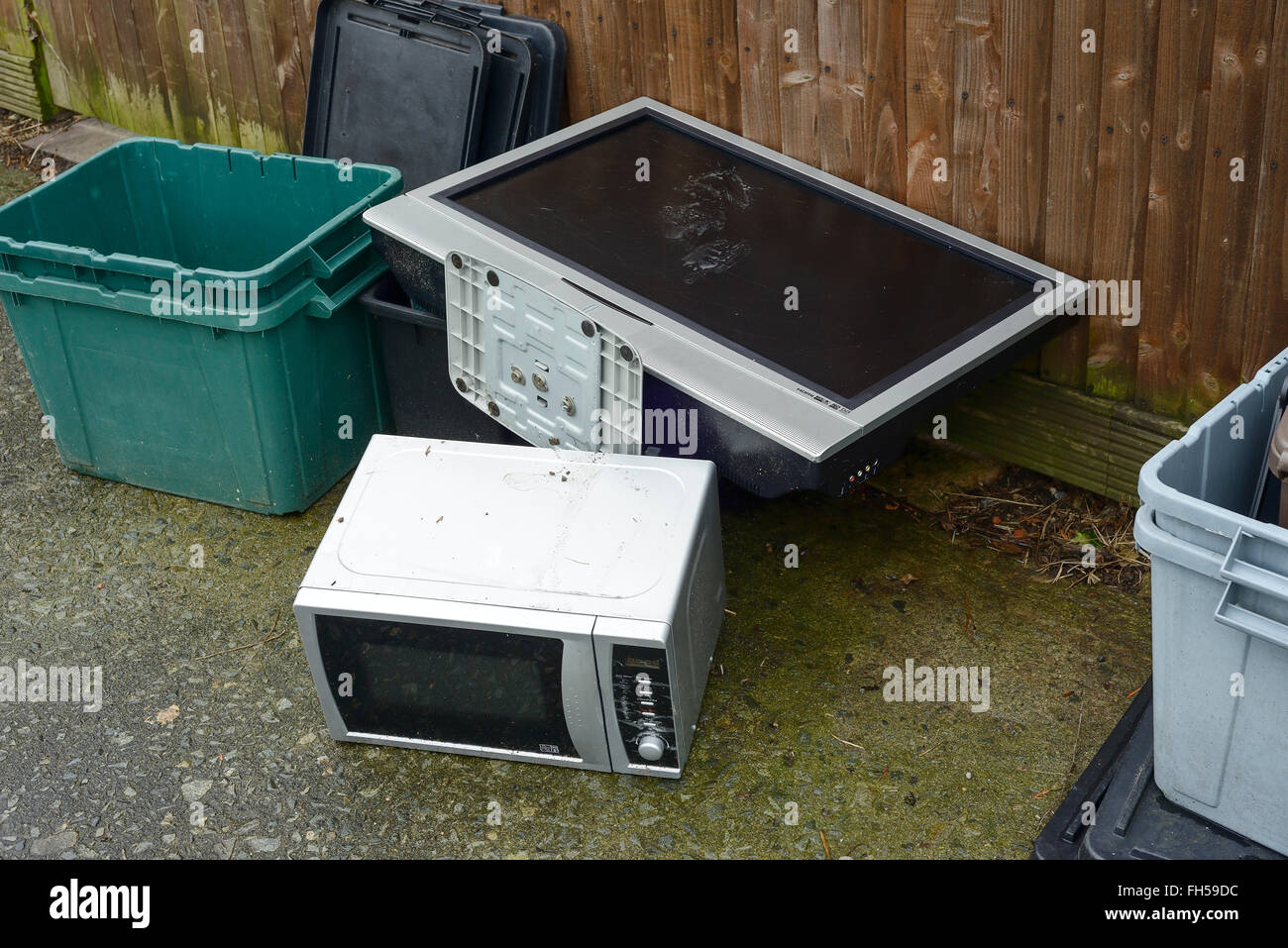An old TV and microwave oven dumped on a pavement Stock Photo