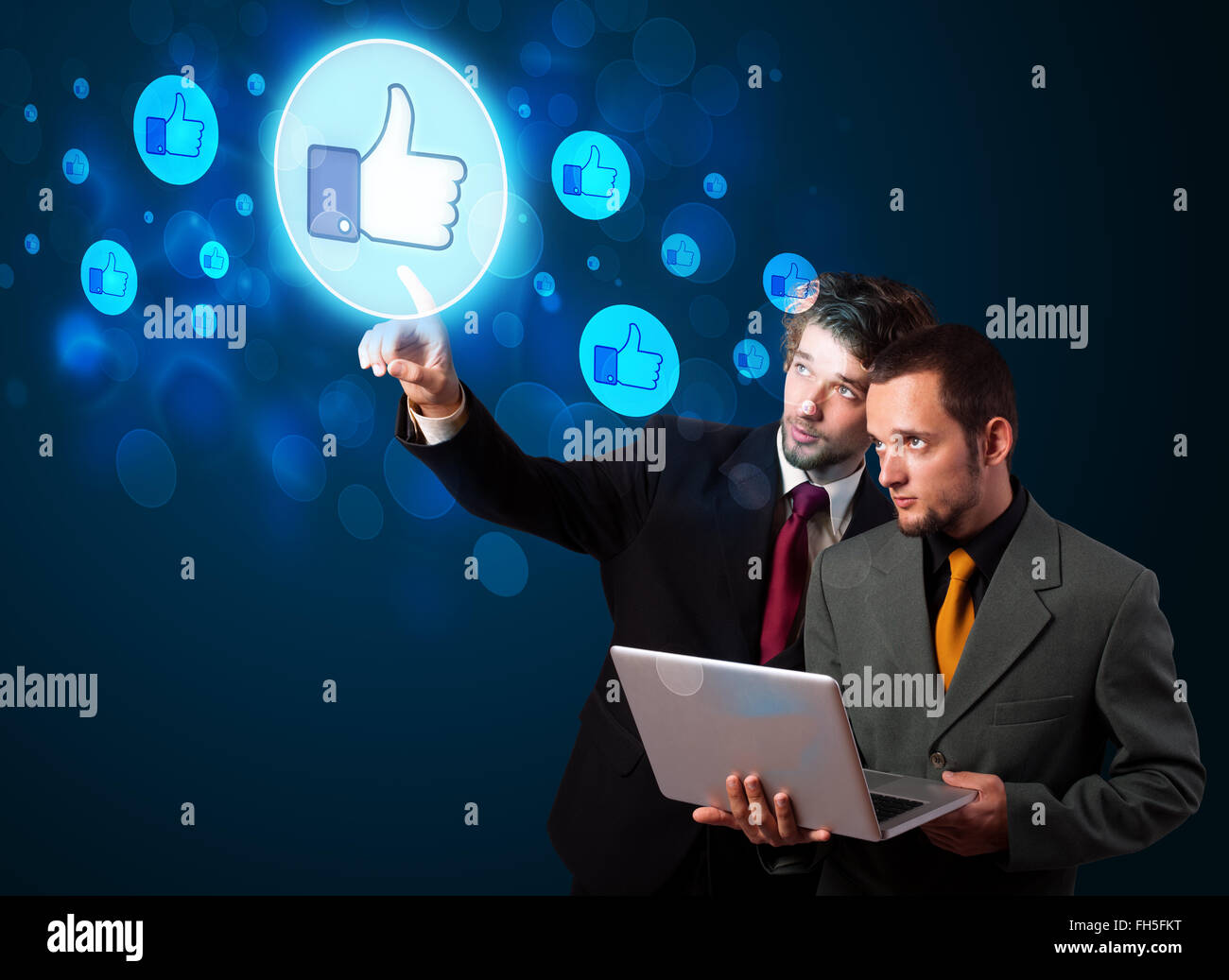 Young business people pressing thumbs up button on modern social ...