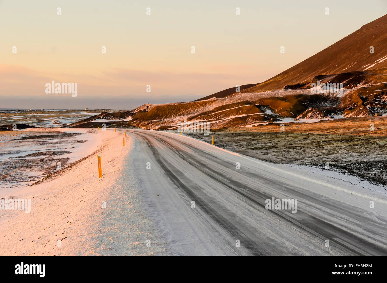 Icy winter road with snow markers at road edge Reykjannes Peninsula Iceland Stock Photo