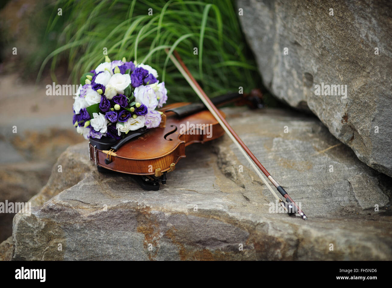 beautiful bridal bouquet and violin on the rock Stock Photo